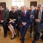 Uczestnicy sesji, na pierwszym planie siedzą trzej mężczyźni i kobieta