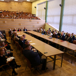 uczestnicy XX Podlaskiego Forum Ekonomistów przy stołach w trzech rzędach na auli WSFiZ. W tle publiczność na widowni. 