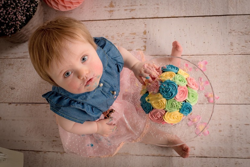 Mała dziewczynka spogląda w obiektyw jednoczesnie jedząc tort  .jpg