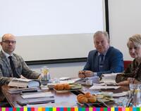 Członkowie Zarządu Województwa Podlaskiego podczas posiedzenia siedzą po obu stronach stołu w sali konferencyjnej