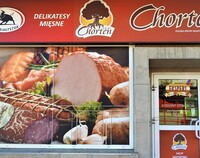 Sklepowa witryna delikatesów mięsnych ze zdjęciem polędwicy na szybie