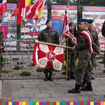 Żołnierze ze sztandarem przy tablicy pamiątkowej