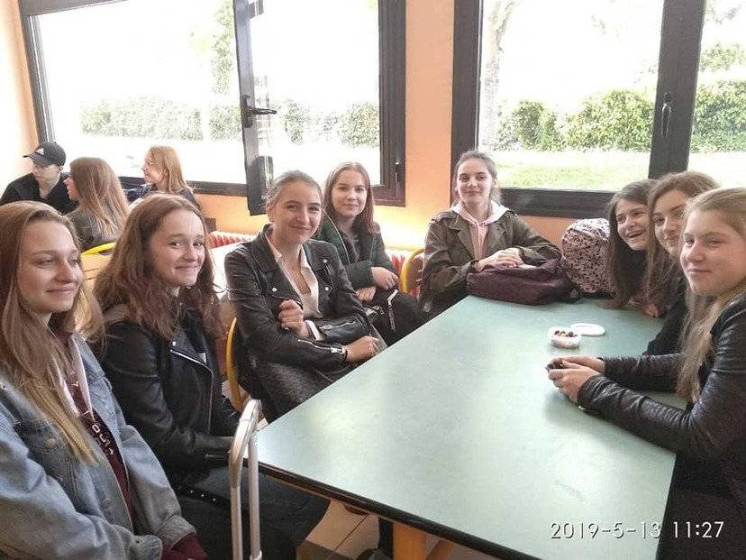 Grupa uśmiechniętych uczniów siedząca przy stole