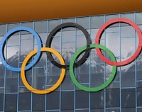 Pięć kółek olimpijskich na szklanej elewacji budynku