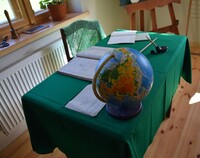biurko szkolne przykryte zielonym suknem, na nim globus i materiały nauczyciela).jpg