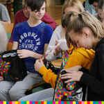 Młodzież przeglądająca zawartość toreb z logo Województwa Podlaskiego