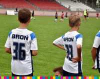 Troje młodych piłkarzy na murawie boiska.