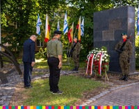 Dwaj żołnierze pełnią wartę przy pomniku, marszałek Artur Kosicki i harcerz oddają hołd przed pomnikiem i składają kwiaty