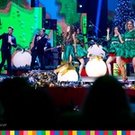Maja Hyży występuje na scenie wraz z kobietami ubranymi w zielone suknie