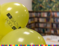 żółte balony z napisem Książnica Podlaska. w tle regały z książkami