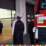 Ksiądz dokonuje poświęcenia pojazdu w obecności strażaków OSP