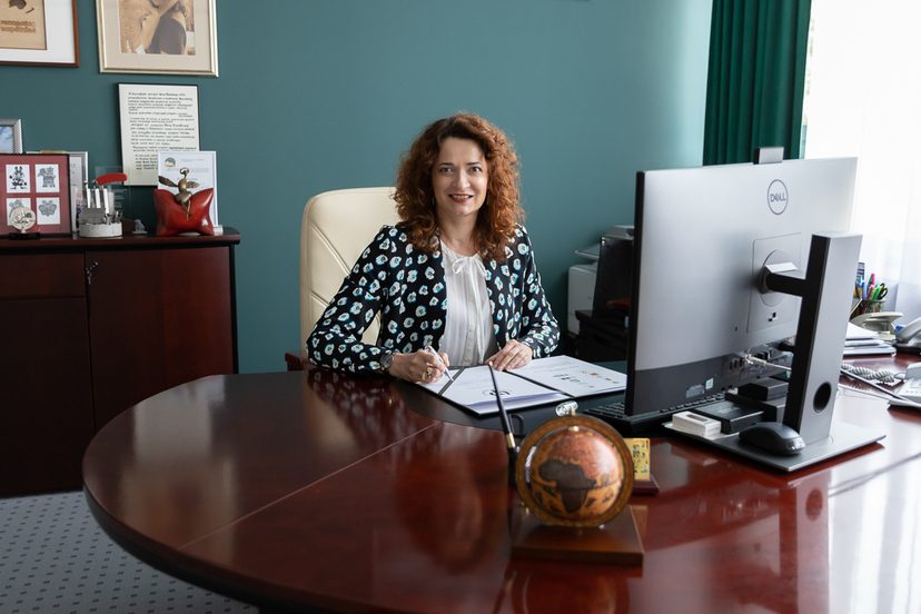 Prof. Marta Kosior - Kazberuk siedzi za biurkiem z ogromnym monitorem