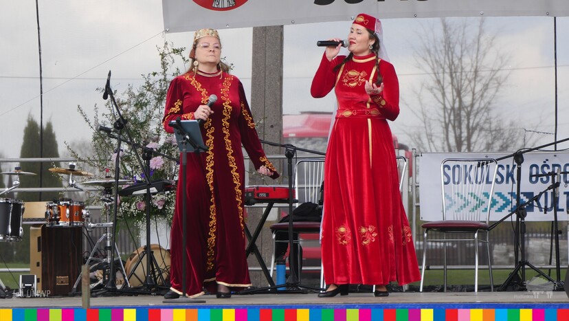 Dwie kobiety w tatarskich strojach występują na scenie.