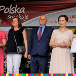 Cztery kobiety, dwie z nich trzymają dyplomy i mężczyzna, stoją na scenie 