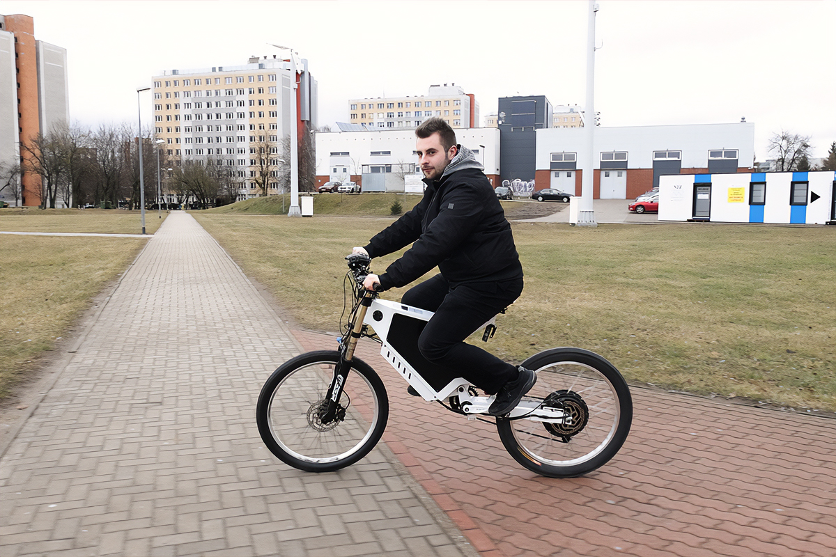 Damian Orzechowski jedzie na swoim rowerze elektrycznym