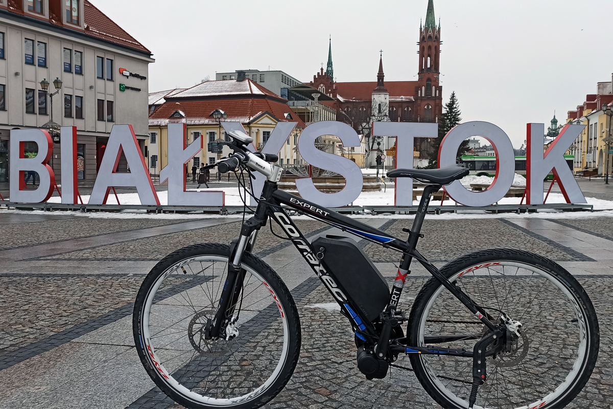 czarny rower stojący przed napisem Białystok