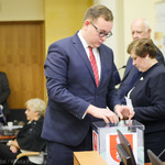 Radny Sebastian Łukaszewicz wrzuca kartę do głosowania