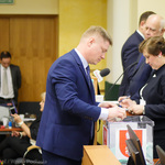 Marek Malinowski wrzuca kartę do głosowania do urny