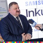 Wicemarszałek województwa udziela wywiadu TVP - stojąc na tle ekranu z logo firmy Samsung 