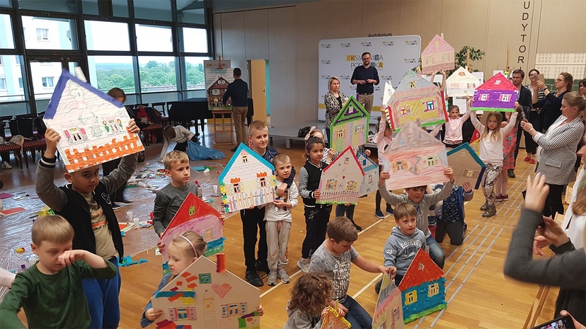 Dzieci - uczestnicy spotkania - prezentują pomalowane domy