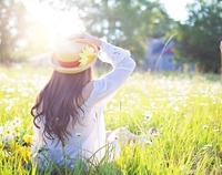 Kobieta w kapeluszu na słonecznej łące latem