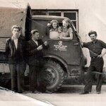 Zdjęcie czarno-białe. Dwie dziewczyny w szoferce auta i trzech mężczyzn obok samochodu z napisem Powiatowe Zakłady Mleczarskie - zdjęcie z archiwum Spółdzielni Mleczarskiej w Łapach