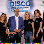 Marszałek Kosicki z czterema dziewczynami na tle ścianki Disco pod Gwiazdami.