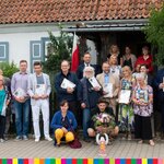 Wicemarszałek S. Derehajło z innymi laureatami i właścicielką domu przed gankiem -zdjęcie grupowe.