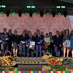Organizatorzy Dożynek na wspólnym zdjęciu z kilkunastoma wyróżnionymi przez Zarząd Województwa Podlaskiego rolnikami. 