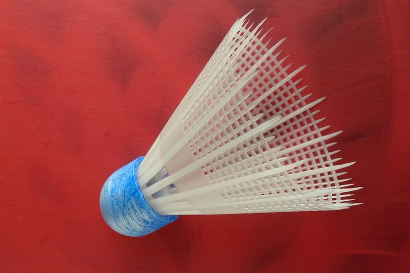 Biała lotka do badmintona na czerwonym tle