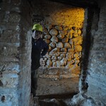 Robotnik w kasku znajdujący się w przestrzeni z kamienistych ścian.
