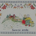 Makatka z wizerunkiem dwójki dzieci siedzących z wędkami nad wodą i napis: Świeża woda. 