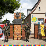 Żołnierze pełniący wartę. Poczet sztandarowy oraz żołnierze stojący przy tablicy pamiątkowej.