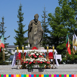Ołtarz przed pomnikiem Jana Pawła II obok ołtarza powiewają flagi