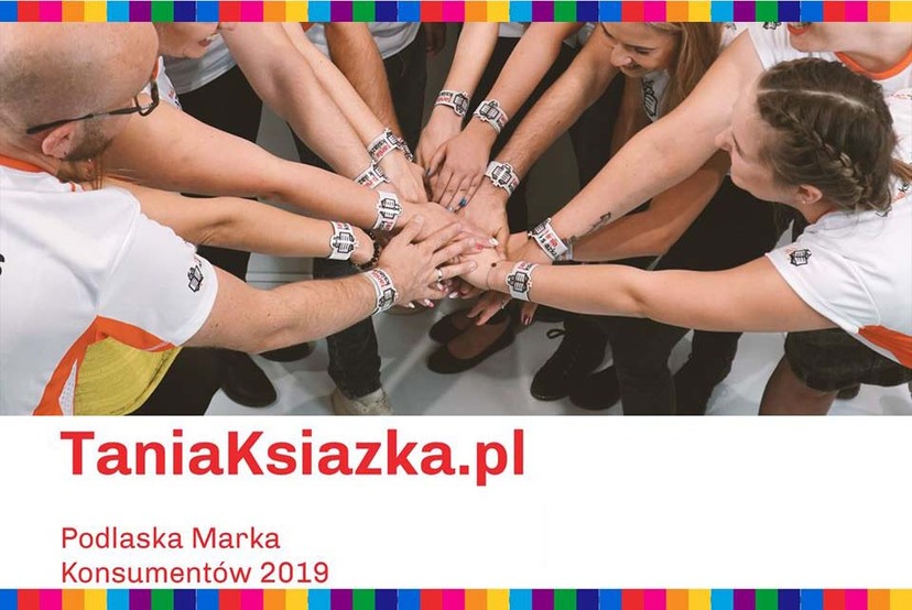 Ręce kilku osób połączone w jednym uścisku. Na dole napis TaniaKsiązka.pl