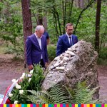 Przedstawiciele Muzeum w Tykocinie oddają pamięć zamordowanym Żydom tykocińskim przed kamiennym pomnikiem. W tle las