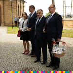 Trzech mężczyzn i kobieta stojących przed kościołem. 