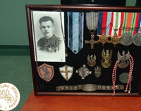 Czarno-białe zdjęcie z wizerunkiem żołnierza. Obok wiszą ordery oraz odznaczenia