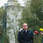 Marszałek Artur Kosicki  stojąc na tle obserwatorium mówi do mikrofonów .