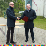 Marszałek Artur Kosicki i rektor UwB podają sobie dłonie. Marszałek trzyma teczkę.