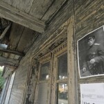 Widok na plakat ze młodym żołnierzem w mundurze z czasów carskich na ścianie starego drewnianego domu