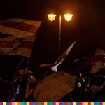 Publiczność z parasolami i flagami biało - czerwono - białymi..