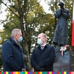Marszałek Artur Kosicki i przewodniczący Józef Mozolewski stoją przed pomnikiem ks Jerzego Popiełuszki.