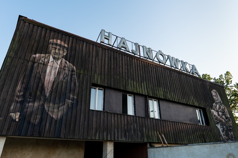 Stary dworzec Hajnówka z portretem mężczyzny na ścianie.