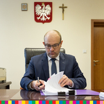 Artur Kosicki, Marszałek Województwa Podlaskiego siedzący przy stole i podpisujący umowy. 