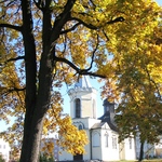 Zdjęcie kościoła. Na pierwszym planie drzewo o żółtych liściach