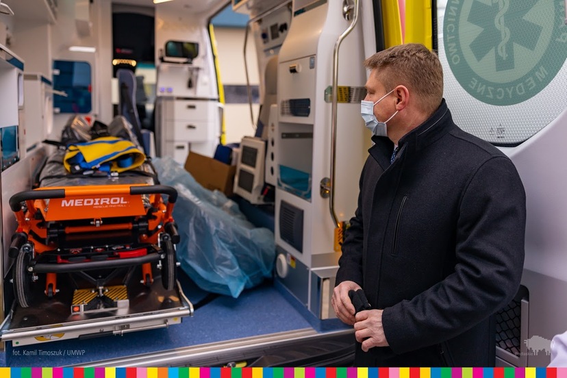 Marek Malinowski, członek Zarządu Województwa Podlaskiego. W tle wnętrze ambulansa ze sprzętem medycznym