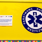 Na karoserii ambulansa logotyp Państwowego Pogotowia Ratunkowego oraz informacja na temat projektu samorządowego wsparcia służby zdrowia w województwie podlaskim