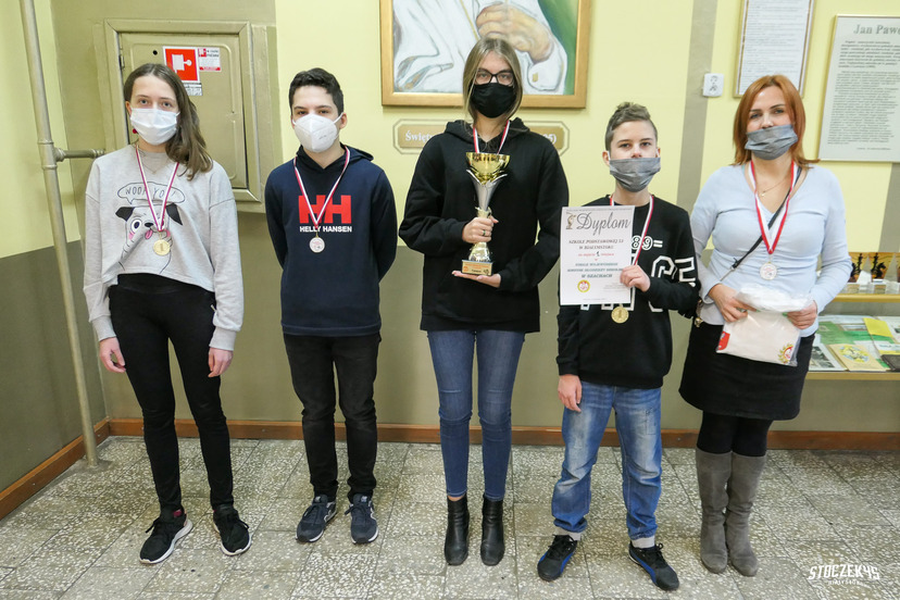 Młodzi szachiści z SP 53 Białystok pozujący do zdjęcia z pucharem i dyplomem