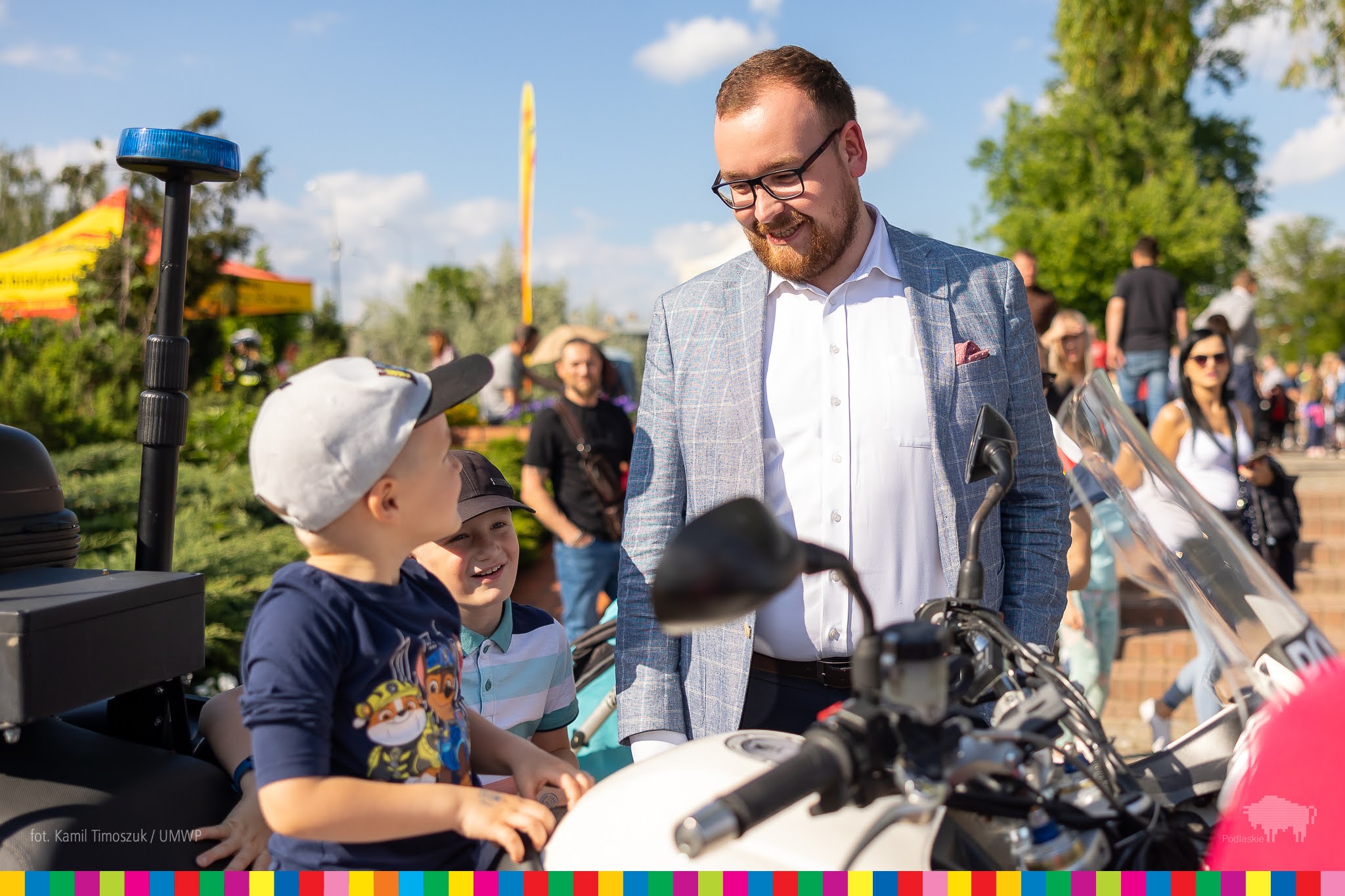 wicemarszałek Sebastian Łukaszewicz stoi przy motorze na którym siedzą chłopcy